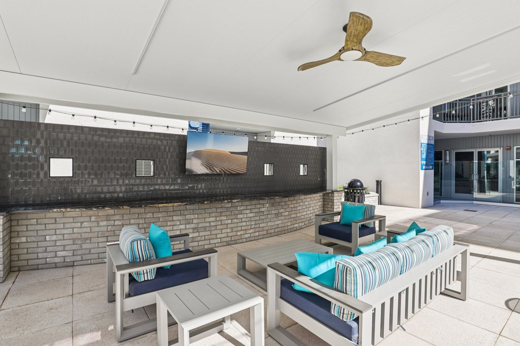 A patio with a table and chairs and a ceiling fan.