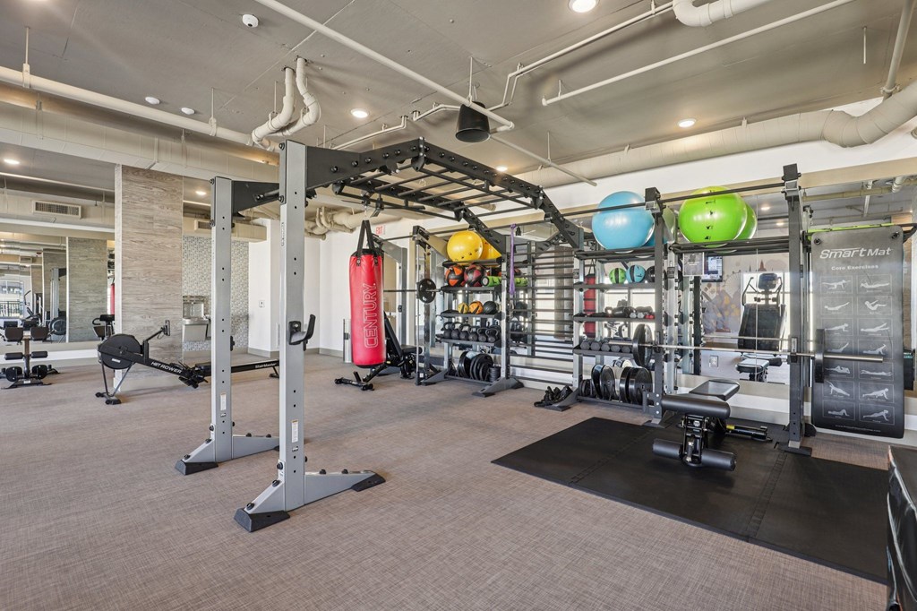 A gym with a variety of equipment including a punching bag.