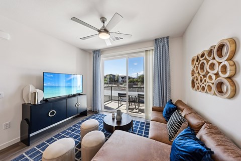 A living room with a brown couch and a television on a cabinet.