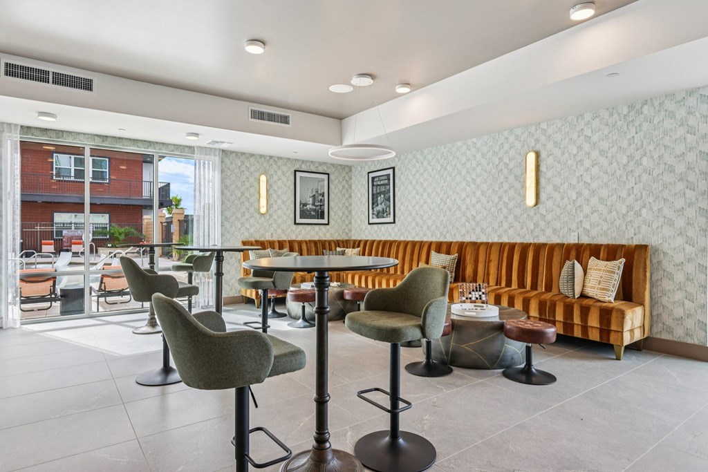 A restaurant with a white ceiling and grey chairs.