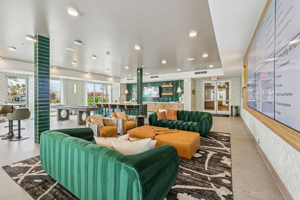A modern living room with green and orange sofas and a white wall with a menu board.