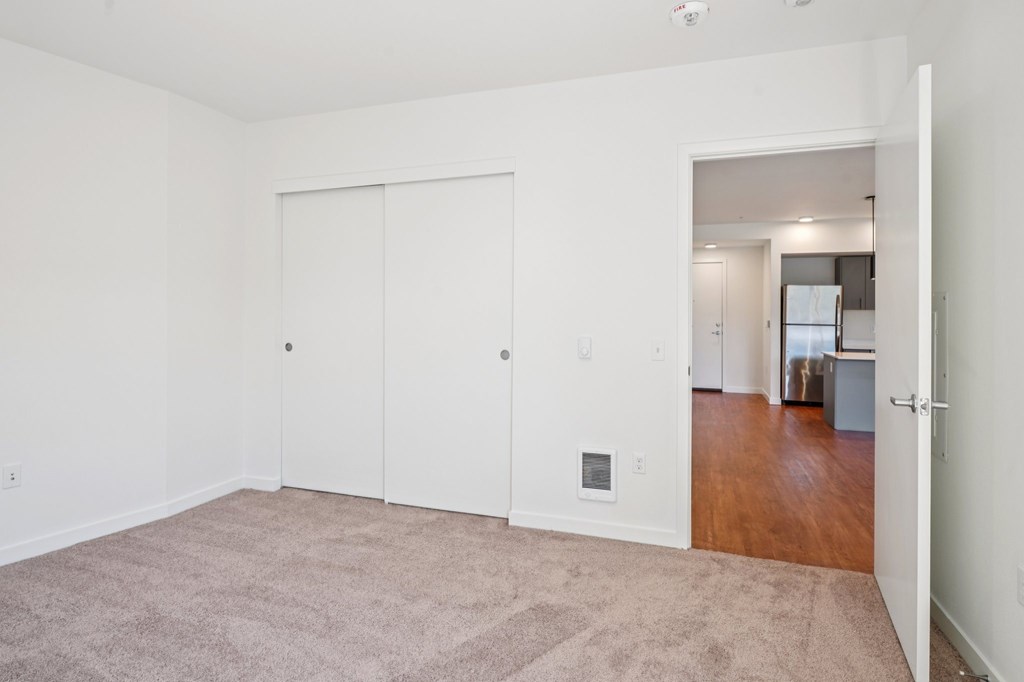 A room with a carpeted floor and a white door.