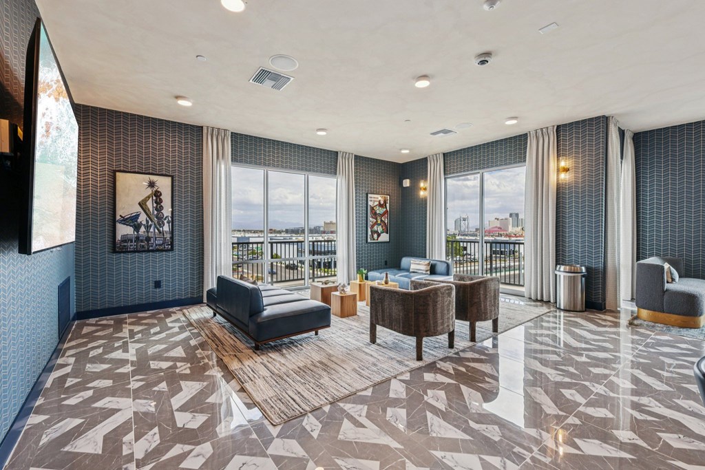 A spacious living room with a large window and a view of the city.