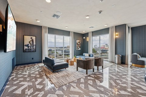 A spacious living room with a large window and a view of the city.