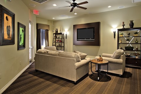 A living room with a couch, a chair, and a television.