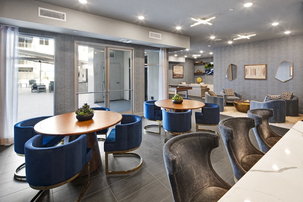 a communal area with tables and chairs in the lobby of a building at Aura Vegas Apartments, Nevada