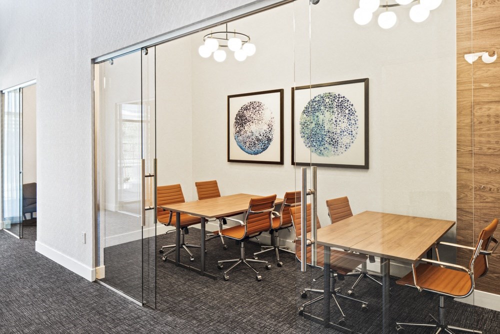 a conference room with tables and chairs and paintings on the wall a conference room with tables and chairs and paintings on the wall at Aura Vegas Apartments, Las Vegas, 89103