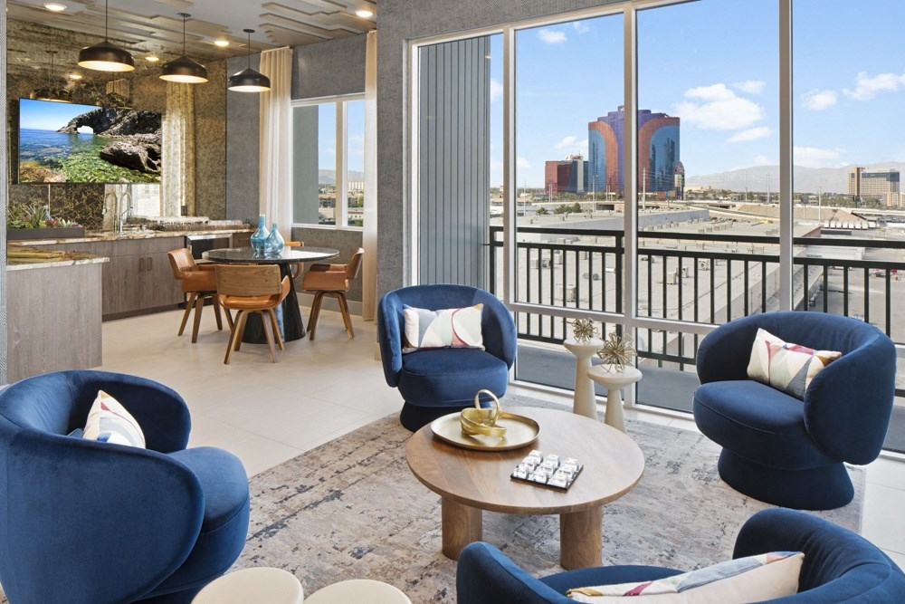 a living room with blue chairs and a view of the city at Aura Vegas Apartments, Nevada, 89103