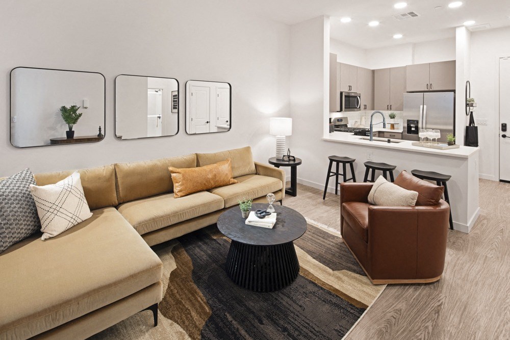 a living room with couches and a table in front of a kitchen at Aura Vegas Apartments, Las Vegas, 89103
