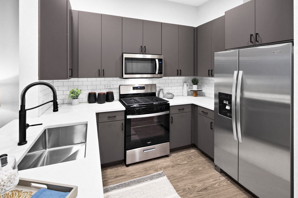 a kitchen with stainless steel appliances and gray cabinets at Aura Vegas Apartments, Las Vegas, 89103