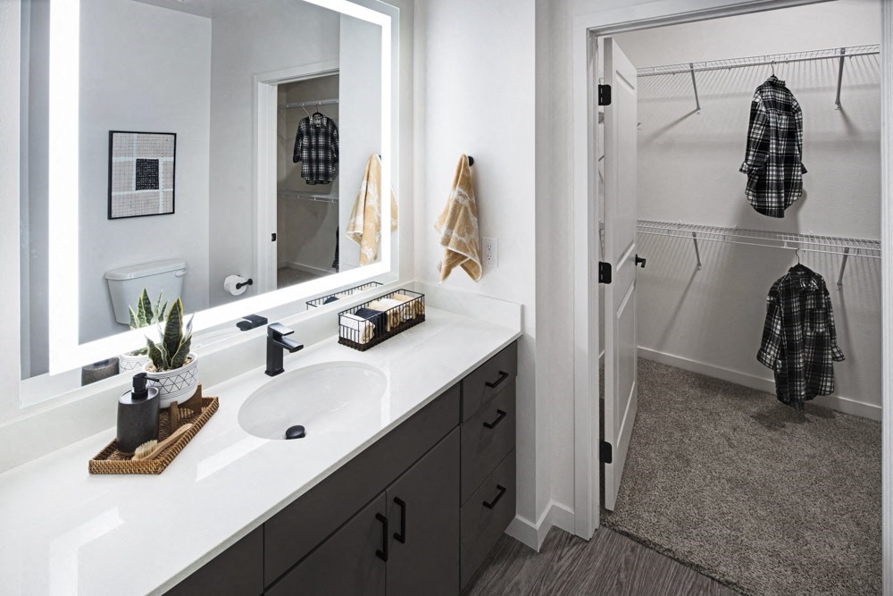 a bathroom with a sink and a mirror and a shower at Aura Vegas Apartments, Las Vegas, NV
