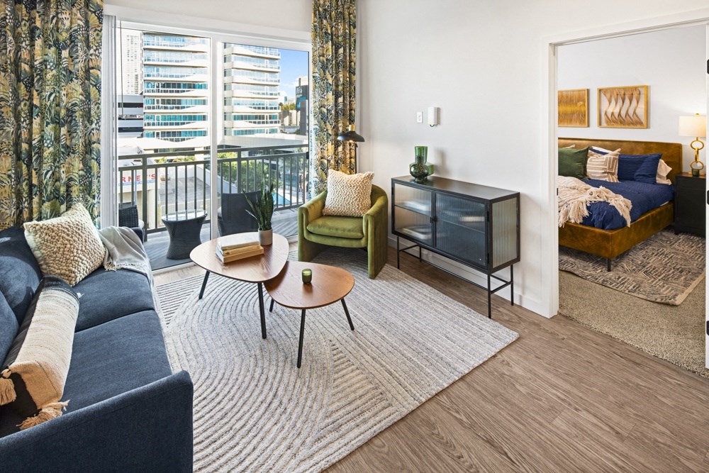 a living room with a couch and a coffee table and a bedroom with a balcony at Aura Vegas Apartments, Las Vegas
