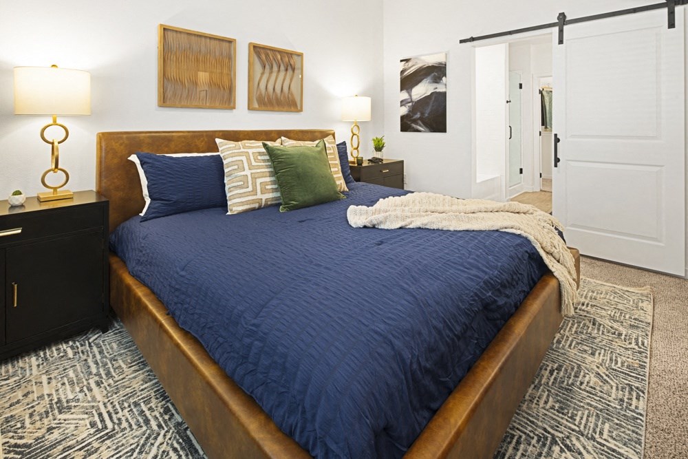 a bedroom with a large bed with blue blankets and pillows a bedroom with a large bed with blue blankets and pillows at Aura Vegas Apartments, Nevada, 89103