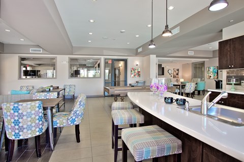 A kitchen with a counter and chairs.