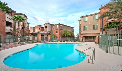 A swimming pool surrounded by a fence and buildings.