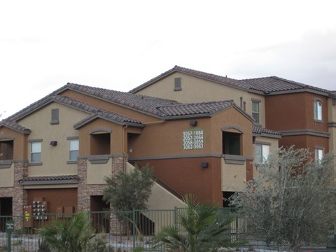 A brown building with a fence in front of it.