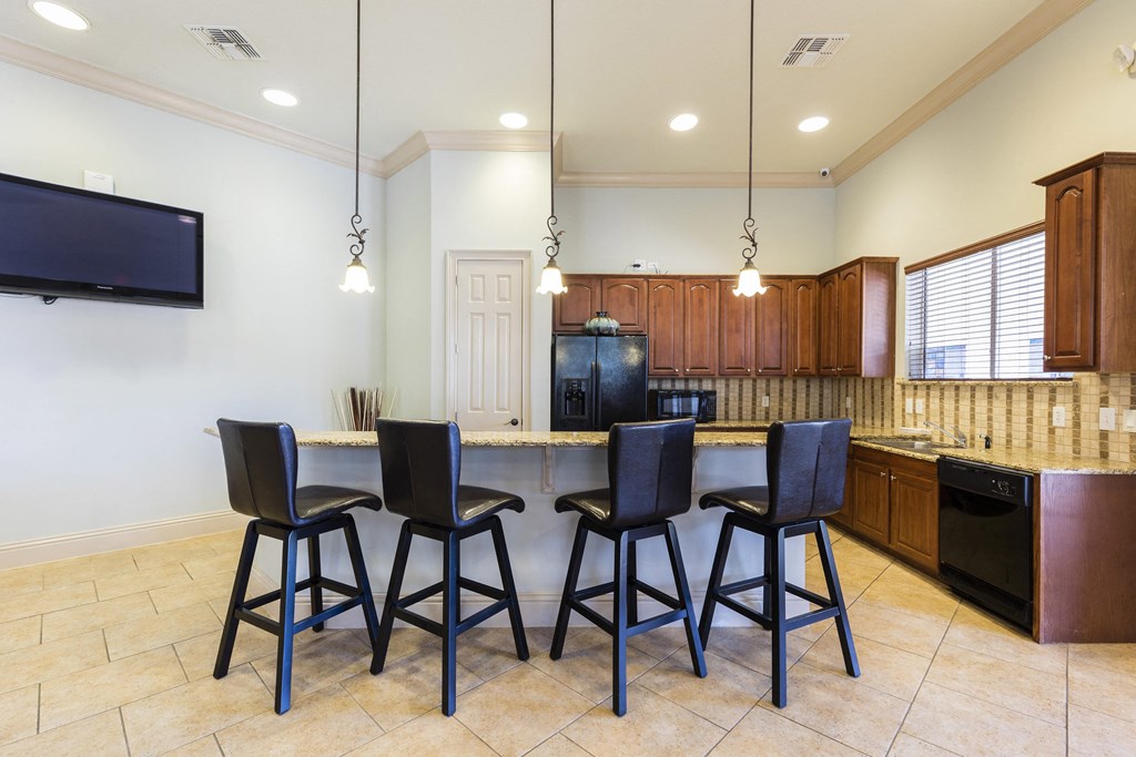 Rapallo Apartments community clubhouse kitchen area equipped with refrigerator, microwave, and dishwasher.