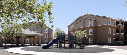 A playground with a slide in front of a building.