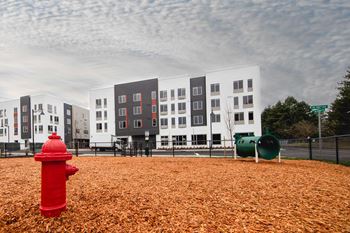a red fire hydrant in front of a building at Hana Apartments, Hillsboro, OR