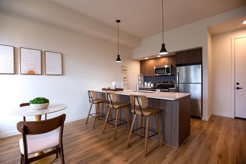 A kitchen with a table and chairs.