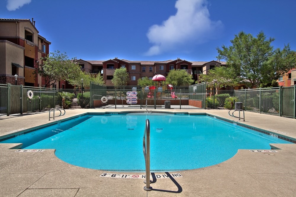 a swimming pool with an apartment building in the background