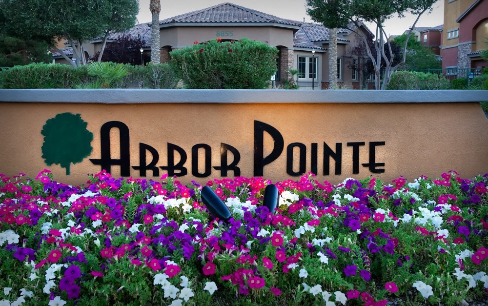 a sign that says arbor point with flowers around it