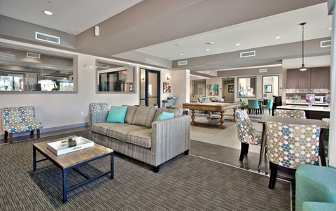 a clubhouse with couches and chairs and a table with chairs