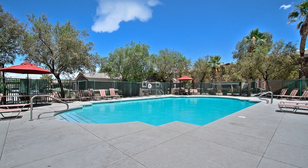 a swimming pool with chairs and umbrellas at the resort