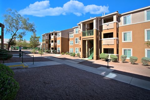 an exterior view of an apartment building with a sidewalk and courtyard