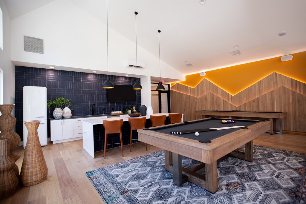 a living room with a pool table and a dining area