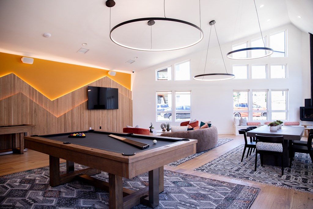 a living room with a pool table and a tv