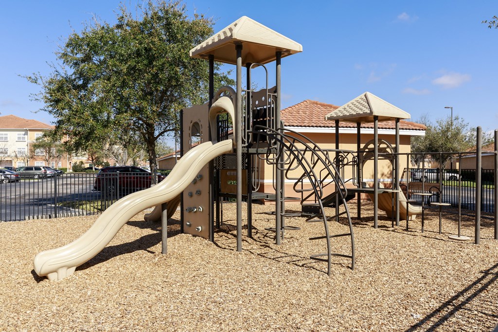 Rapallo Apartments community playground equipped with slide and jungle gym.