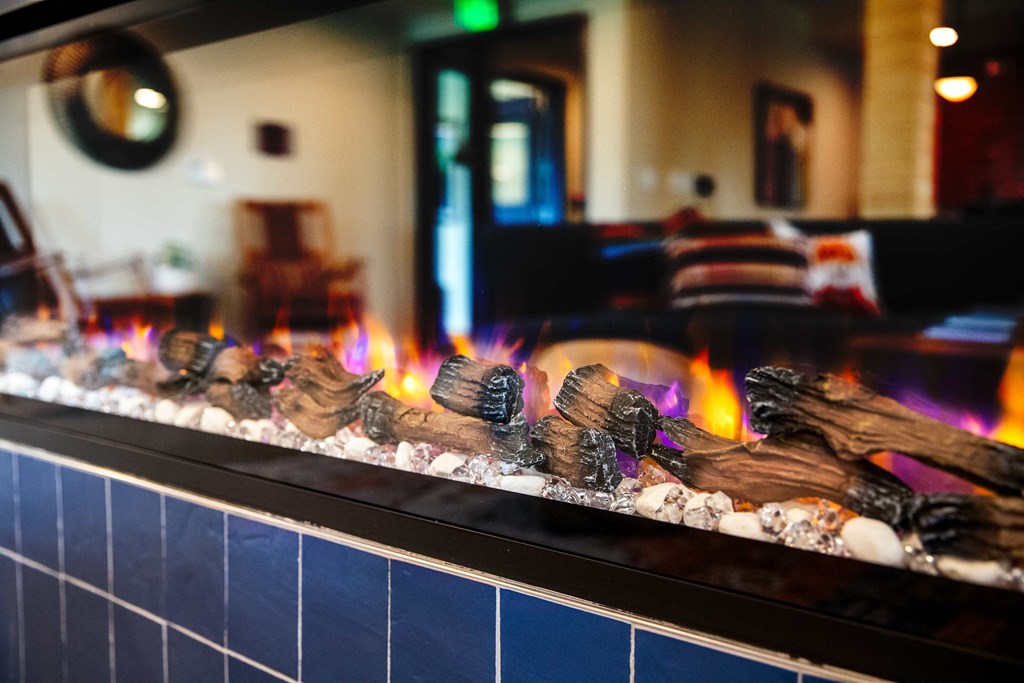 a fireplace in a restaurant with flames and rocks in front of it at Scouter's Mountain, Happy Valley, OR 97086