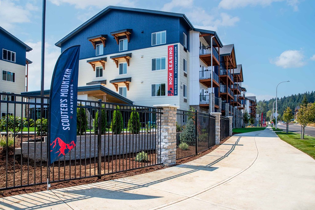 an apartment building with a blue and white facade and a sign on a fenceat Scouter's Mountain, Happy Valley Oregon
