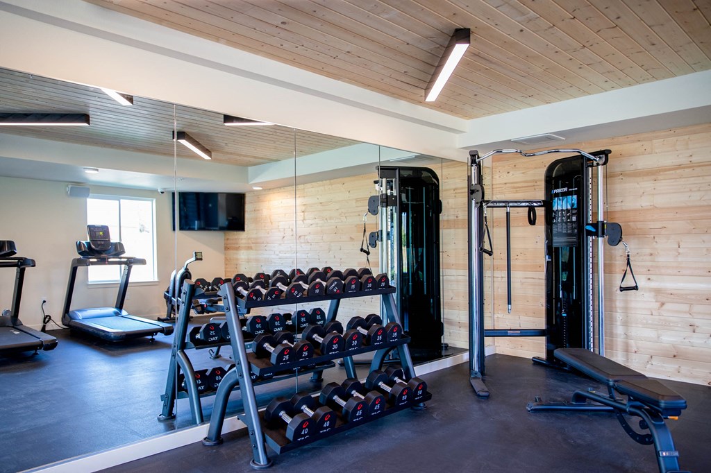 a home gym with a large rack of dumbbells at Scouter's Mountain, Happy Valley, OR