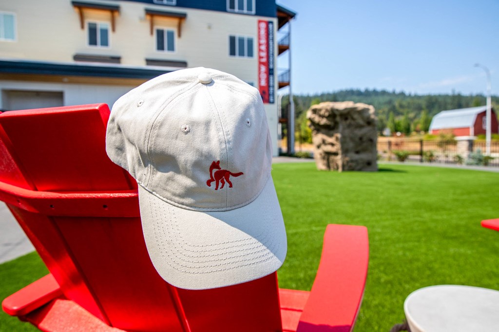 a hat with a red crab on it sits on a red chair in front of a buildingat Scouter's Mountain, Happy Valley