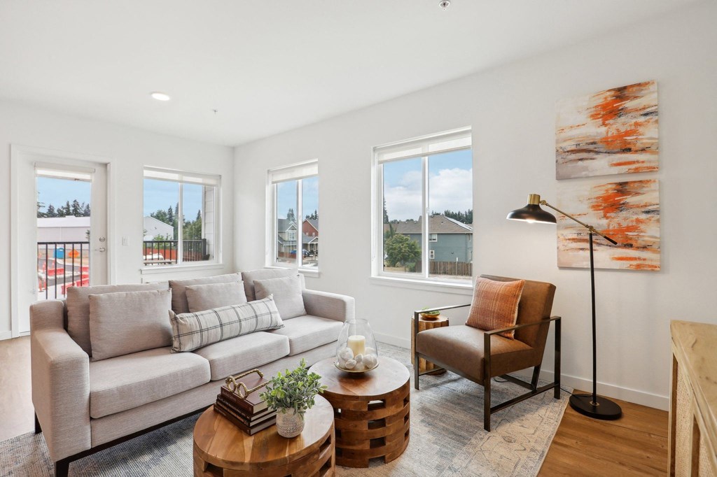 a living room with a couch and a coffee table and windows at The Mill on Maple Apartments, Oregon City, Oregon