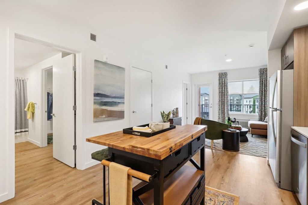 a living room with a wooden table and a kitchen at The Mill on Maple Apartments, Oregon City
