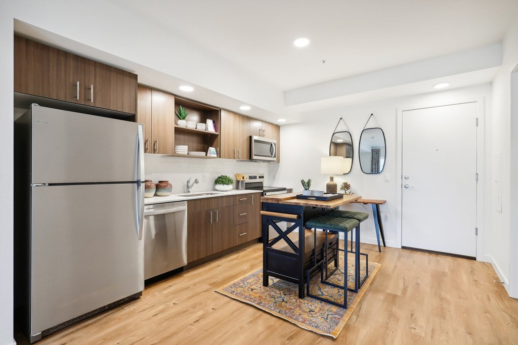 a kitchen with stainless steel appliances and a dining room table a kitchen with stainless steel appliances and a dining room table at The Mill on Maple Apartments, Oregon, 97045