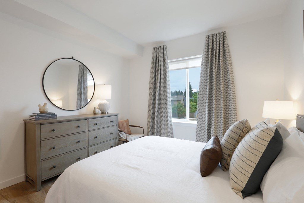 a bedroom with a bed and a dresser and a window at The Mill on Maple Apartments, Oregon City, OR 97045