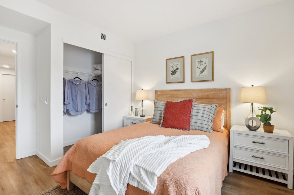 a bedroom with a bed and a closet with clothes in it at The Mill on Maple Apartments, Oregon