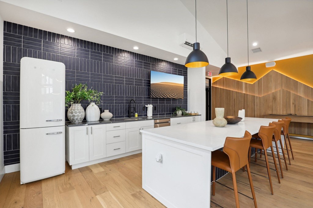 a kitchen with a large white island and a dining table at The Mill on Maple Apartments, Oregon City, OR