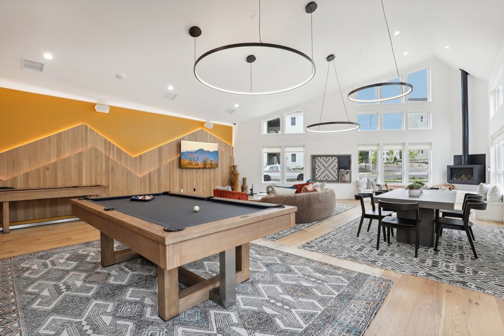 a spacious living room with a pool table and a dining room at The Mill on Maple Apartments, Oregon City, OR 97045