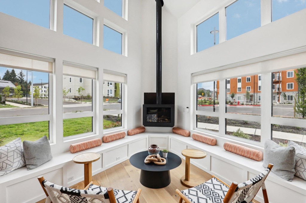 a man sitting in a room with a view of a building at The Mill on Maple Apartments, Oregon