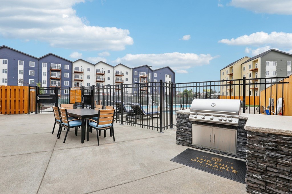 a patio with a grill and a table and chairs at The Mill on Maple Apartments, Oregon