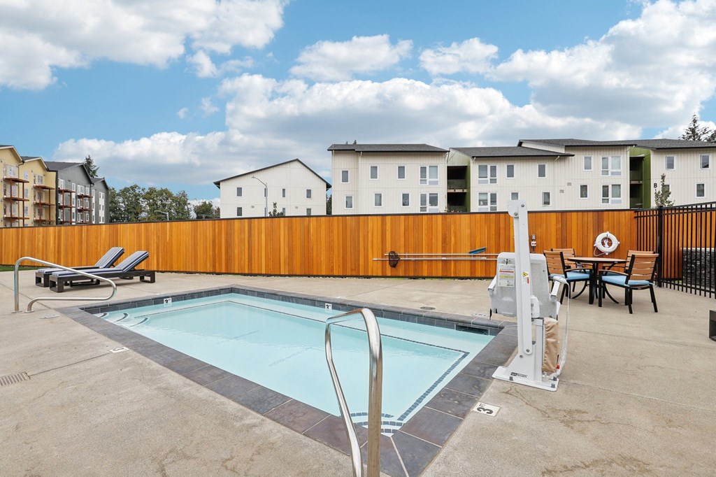 our apartments have a pool and a patio with chairs and tables at The Mill on Maple Apartments, Oregon City, OR