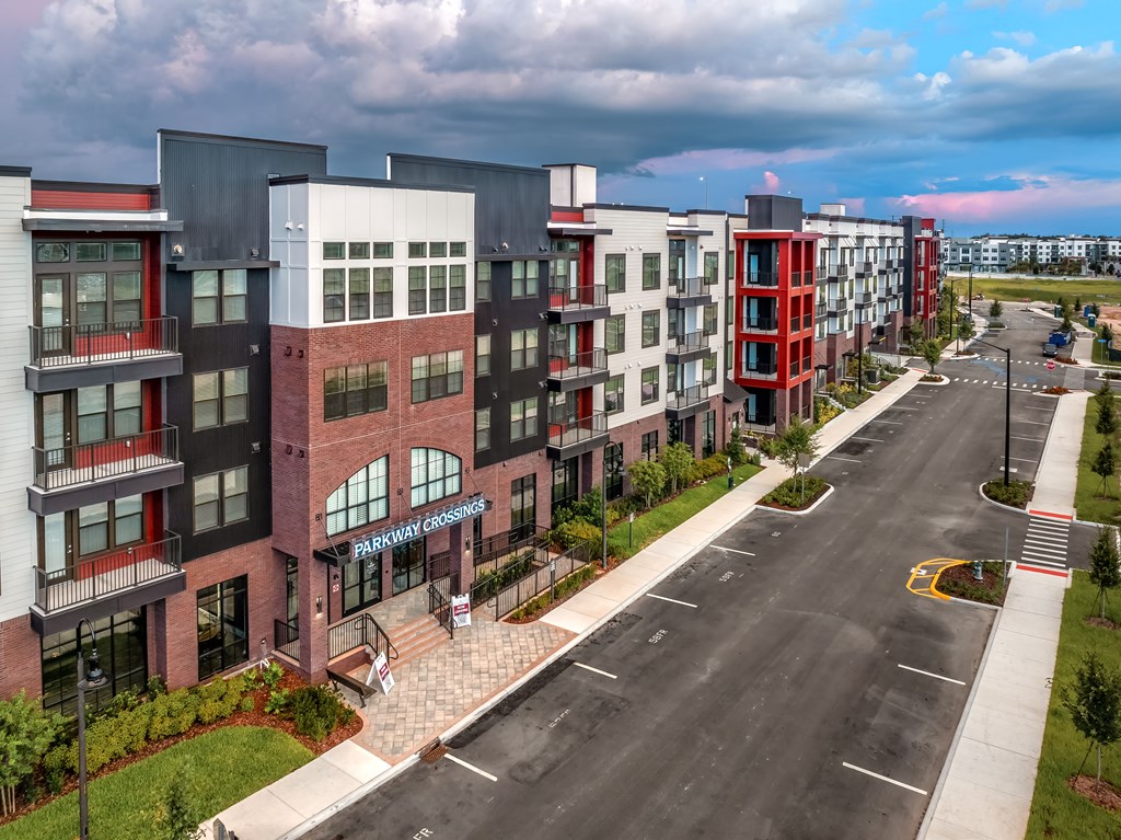 A street view of a multi-story building with the name "PARKWAY CROSSING" on the front.