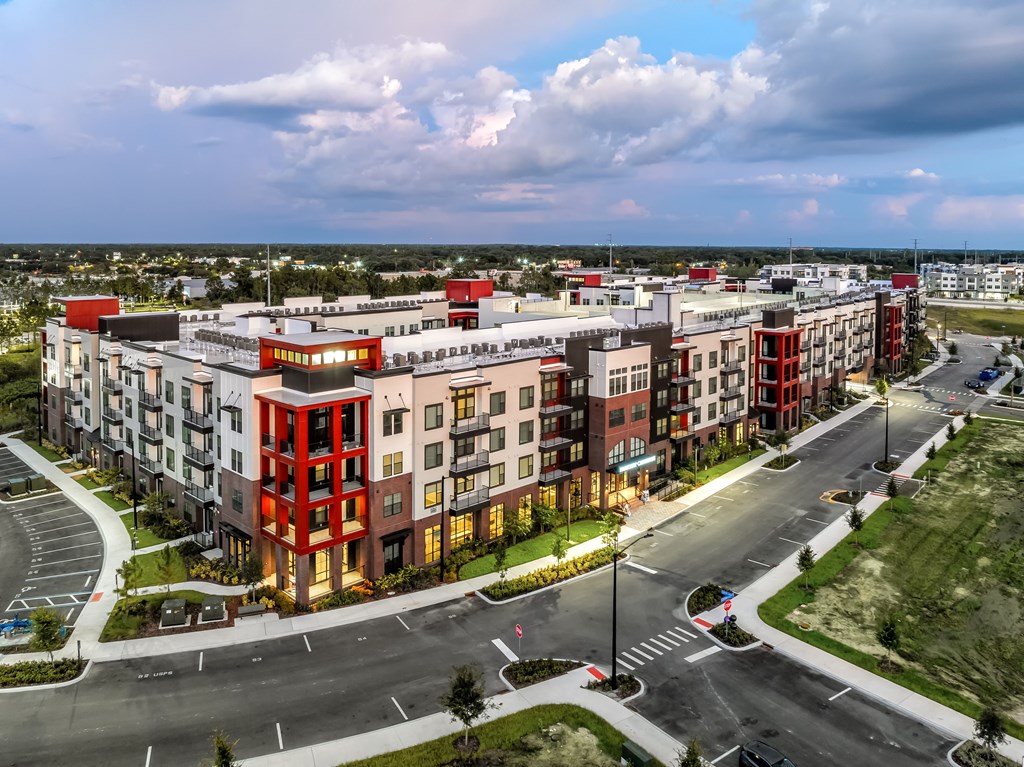 A modern apartment complex with a mix of red, white, and beige buildings.