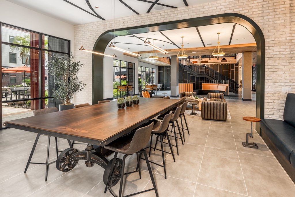 A modern dining room with a long wooden table and chairs.