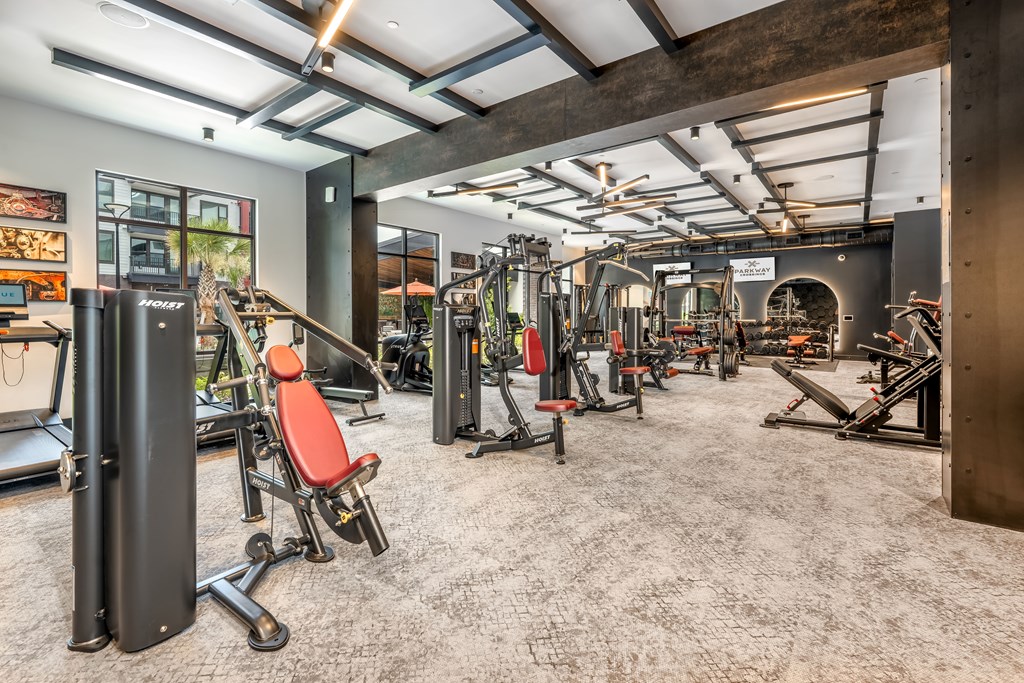 A gym with a variety of equipment including treadmills, weights, and exercise machines.